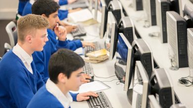 Teenage students using computers in computer room