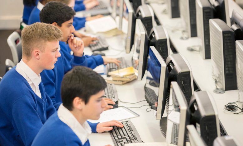 Teenage students using computers in computer room