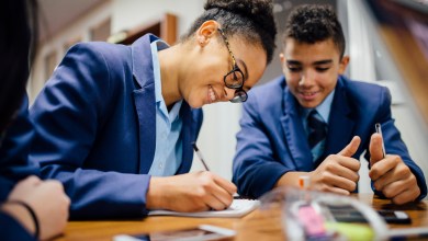 Teen students are working together and taking notes in lesson time at school.